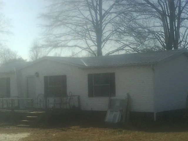 New metal roof on a white painted brick home on a foggy morning in Willmar